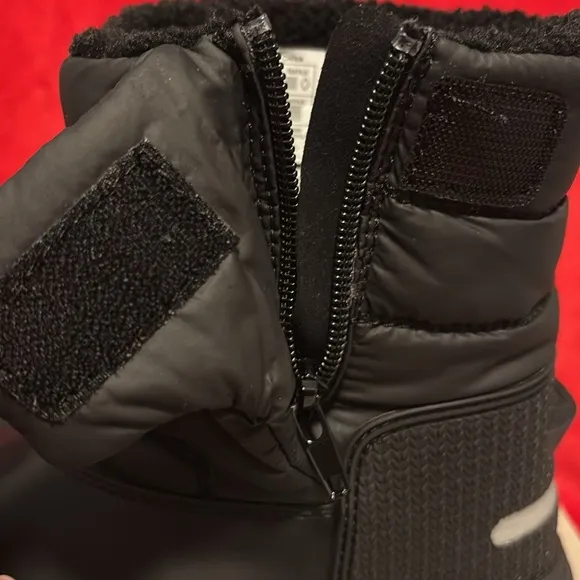 These are a pair of all black insulated Hunter snow boots size 1